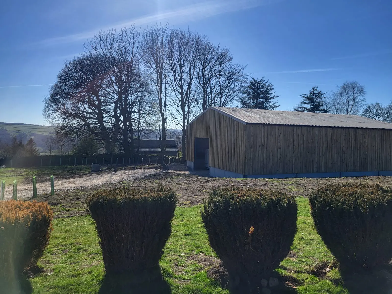 Barn and farmyard view under a clear sky.